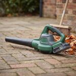 Gustwind 40V cordless leaf blower on a brick patio beside dry autumn leaves